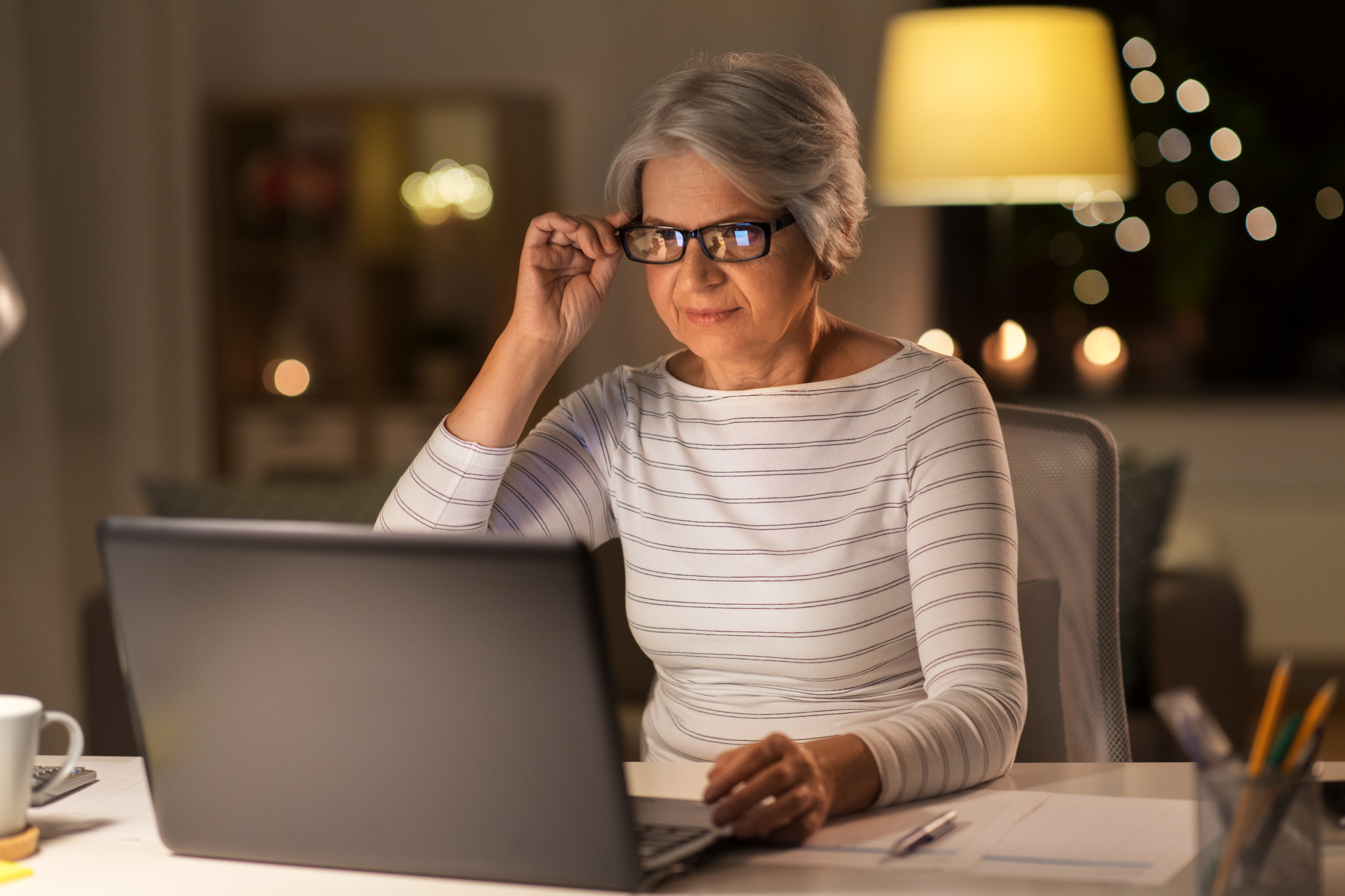 Senior Woman Working on Laptop at Night